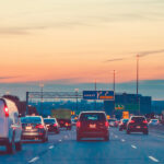 Autos auf der Autobahn bei Sonnenuntergang