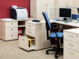 Büroarbeitsplatz mit Computer, Monitor, Schränken und Drucker